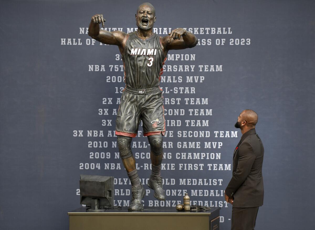 Former Miami Heat NBA basketball player Dwyane Wade looks at a bronze statue in his image during its unveiling ceremony.