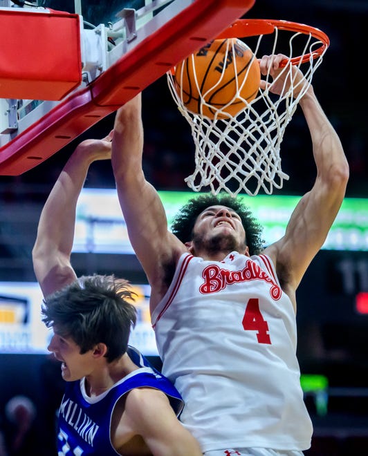 Bradley's Corey Thomas slam dunks over Millikin's Chase Travis in the first half of their college basketball exhibition game Wednesday, Oct. 30, 2024 at the Peoria Civic Center. The Braves defeated the Big Blue 80-63.