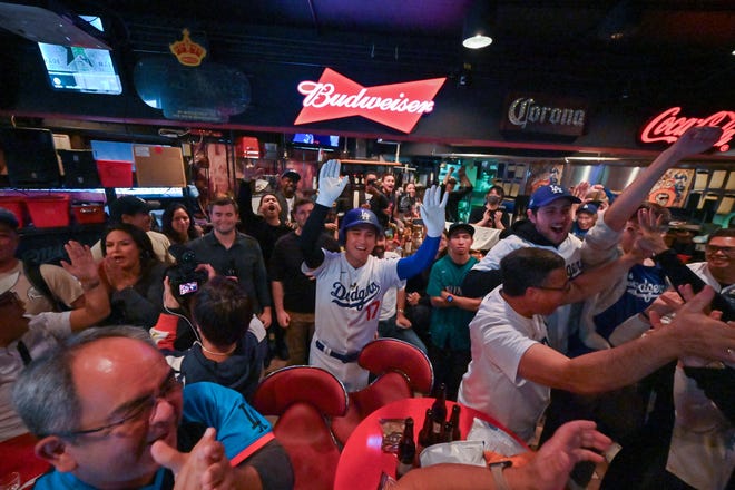 Fans cheer as the Dodgers score in the fifth inning of Game 5 of the World Series at a bar in the Shibuya district of Tokyo.
