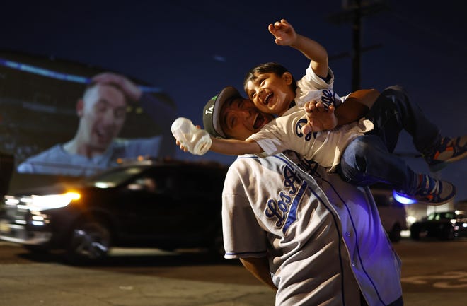 Misael Morales celebrates with his son, Sebastian, in East L.A. after the Los Angeles Dodgers defeated the New York Yankees in Game 5.