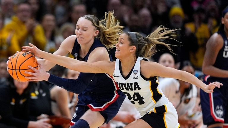 FILE -UConn guard Paige Bueckers, left, fights for a loose...