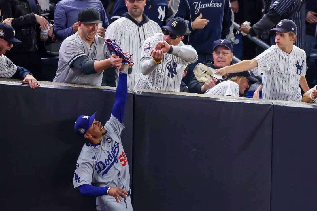 Fans interfere with Mookie Betts of the Los Angeles Dodgers as he attempts to catch a fly ball in foul territory during Game Four of the 2024 World Series against the New York Yankees at Yankee Stadium on Tuesday.