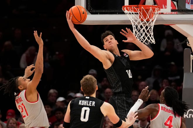 Michigan State center Szymon Zapala (10) reaches for a rebound in front of Ohio State forward Devin Royal (21), teammate Jaxon Kohler (0) and Aaron Bradshaw (4) in the first half of an NCAA college basketball game Friday, Jan. 3, 2025, in Columbus, Ohio.