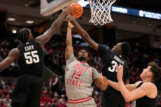 Ohio State forward Sean Stewart (13) shoots as Michigan State forwards Coen Carr (55) and Xavier Booker (34) defend in the first half of an NCAA college basketball game Friday, Jan. 3, 2025, in Columbus, Ohio.