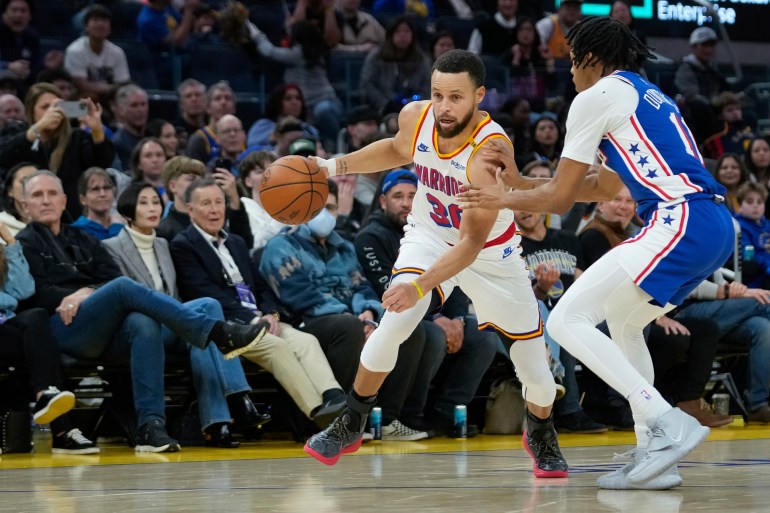 Golden State Warriors guard Stephen Curry moves the ball while defended by Philadelphia 76ers guard Jeff Dowtin Jr. during the second half of an NBA basketball game Thursday, Jan. 2, 2025, in San Francisco. (AP Photo/Godofredo A. Vásquez)