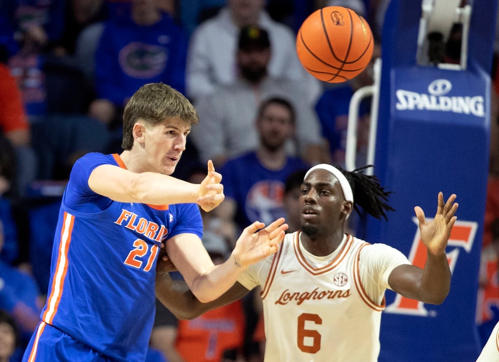 Florida forward Alex Condon (21) passes under pressure from Texas forward Arthur Kaluma (6)...