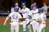 Texas Rangers outfielder Adolis García (53) gets high-fives from his teammates, Texas...