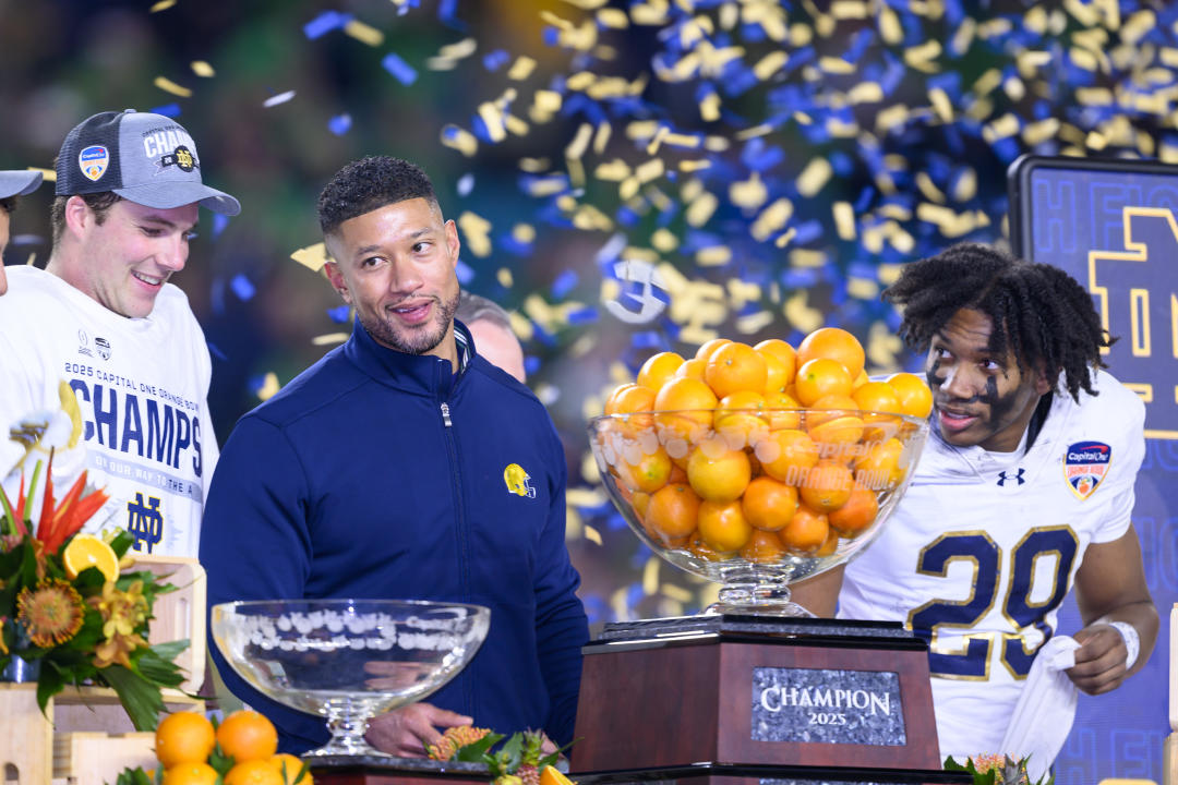 MIAMI GARDENS, FL - JANUARY 09: Quarterback Riley Leonard #13 of the Notre Dame Fighting Irish, Head Coach Marcus Freeman of the Notre Dame Fighting Irish and Cornerback Christian Gray #29 of the Notre Dame Fighting Irish celebrate with the trophy after the Penn State Nittany Lions versus Notre Dame Fighting Irish College Football Playoff Semifinal at the Capital One Orange Bowl on January 9, 2025, at Hard Rock Stadium in Miami Gardens, FL. (Photo by Doug Murray/Icon Sportswire via Getty Images)