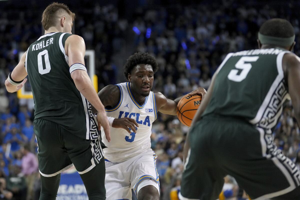 UCLA guard Eric Dailey Jr. dribbles against Michigan State's Jaxon Kohler and Tre Holloman in the second half.