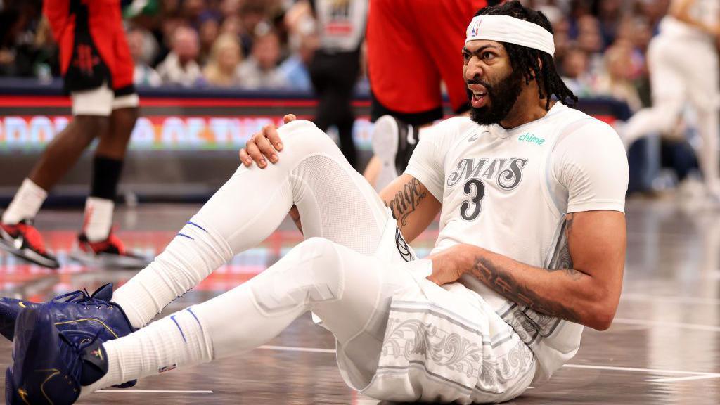 Anthony Davis sits on the court after pulling up with an injury