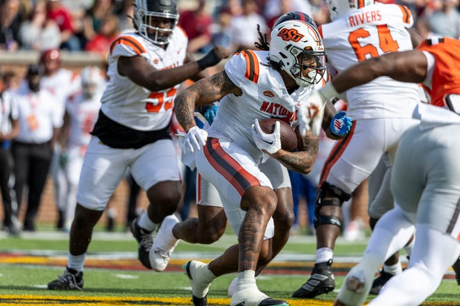 National team running back Ollie Gordon II of Oklahoma State (0) runs the ball during the first half at Hancock Whitney Stadium.