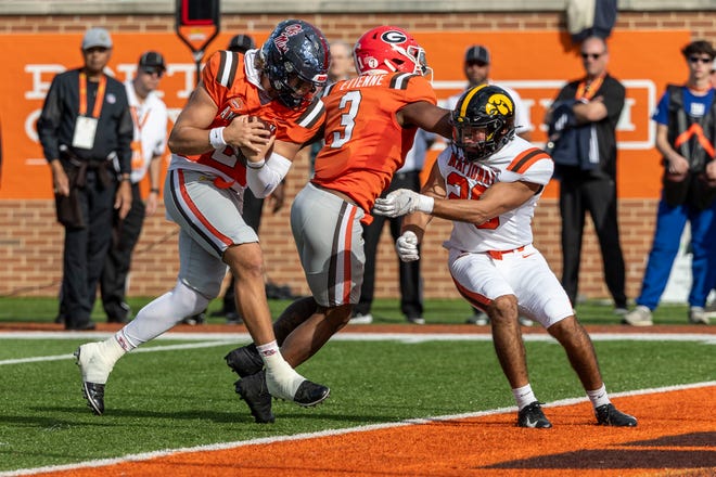 American team quarterback Jaxson Dart of Ole Miss (2) runs the ball against National team defensive back Sebastian Castro of Iowa (29) for a touchdown during the first half of the 2025 Senior Bowl football game at Hancock Whitney Stadium.