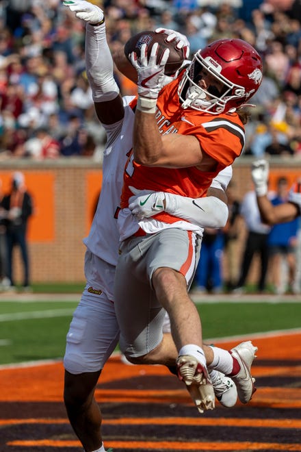 American team wide receiver Isaac TeSlaa of Arkansas (1) makes a two point catch with defense from National team defensive back Johnathan Edwards of Tulane (11) during the first half of the 2025 Senior Bowl football game against the National team at Hancock Whitney Stadium.