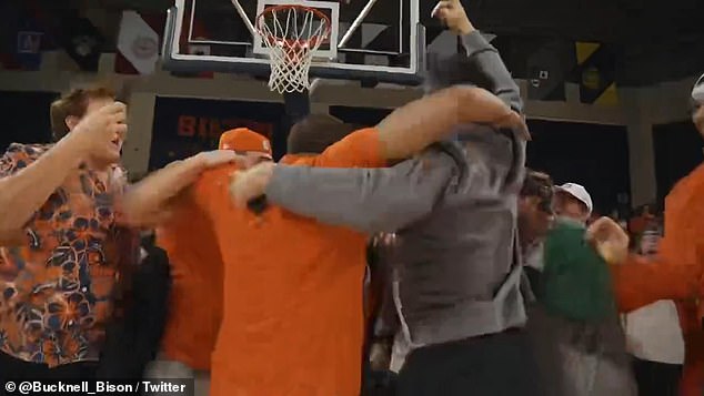 The 49-year-old tossed a high-arching shot that banked off the backboard and through the hoop, setting off a celebration with students