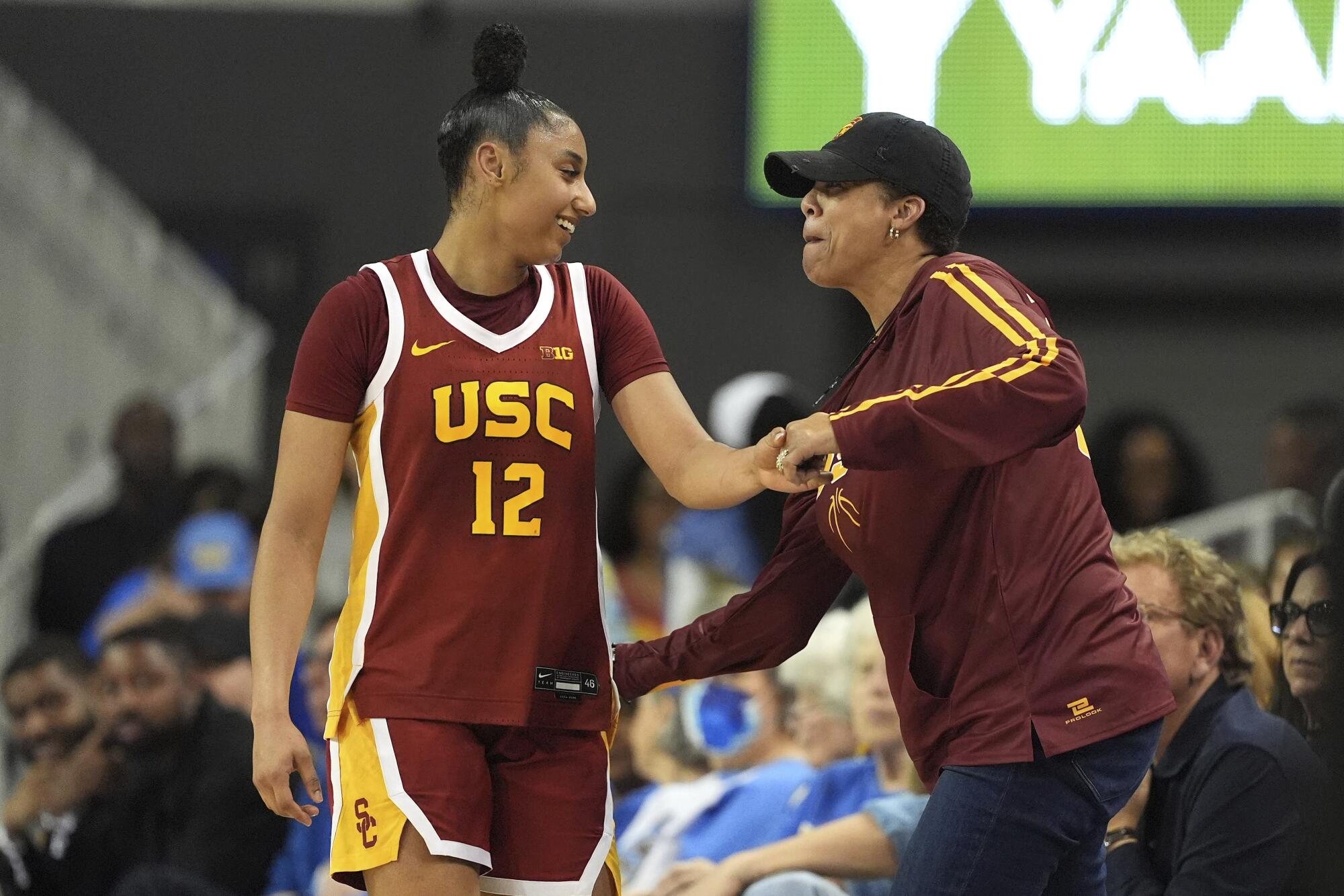 USC guard JuJu Watkins, left, gets a slap on the behind from former USC star Cheryl Miller after making a shot against UCLA.