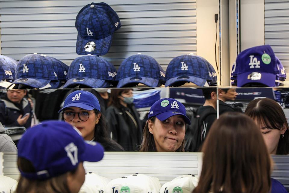 Fans try on Dodgers caps at a souvenir store at the Tokyo Dome on Friday.