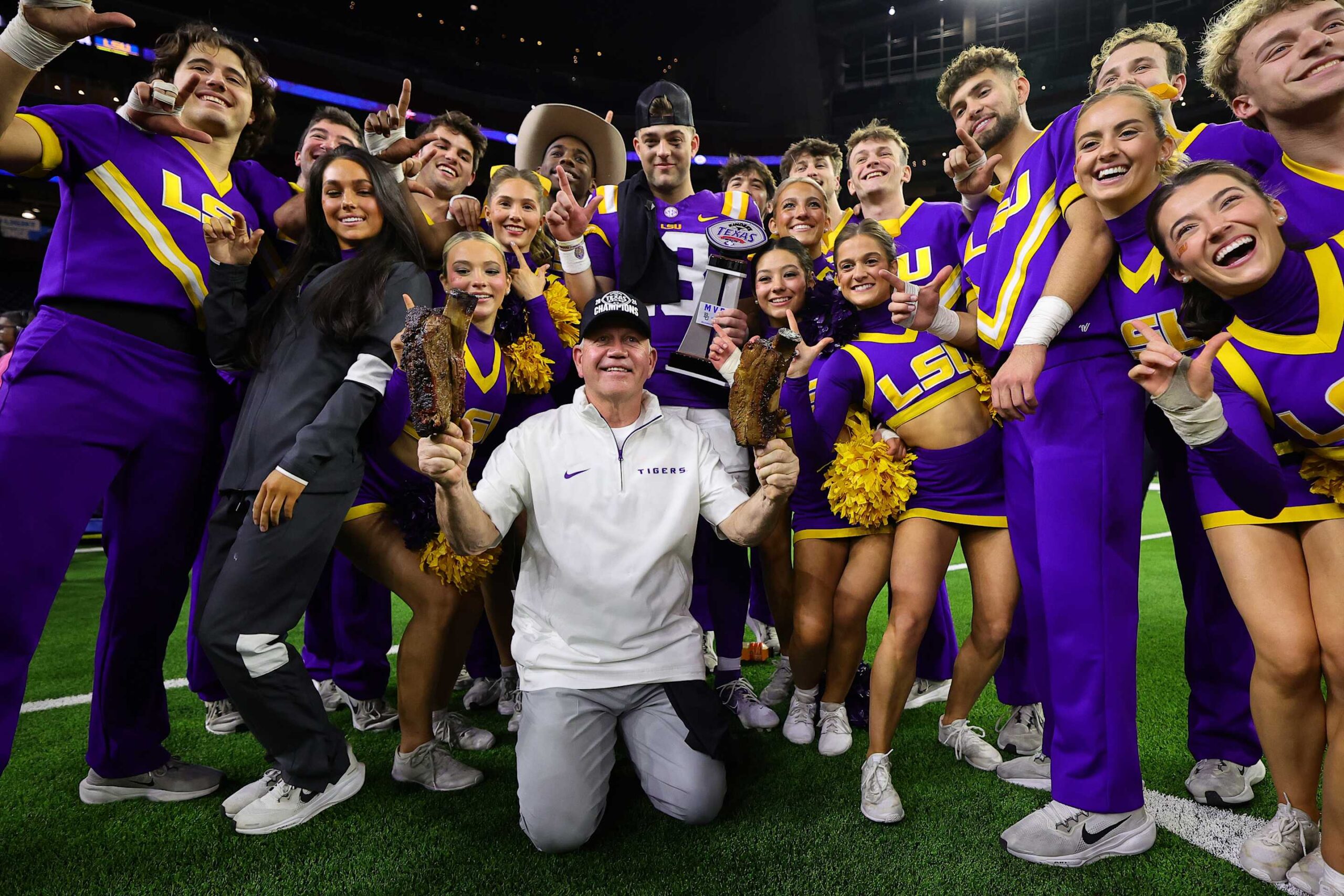 HOUSTON, TEXAS - DECEMBER 31: Head coach Brian Kelly of the LSU Tigers and Garrett Nussmeier #13 of the LSU Tigers pose with cheerleaders after defeating the Baylor Bears 44-31in the Kinder's Texas Bowl at NRG Stadium on December 31, 2024 in Houston, Texas. (Photo by Alex Slitz/Getty Images)