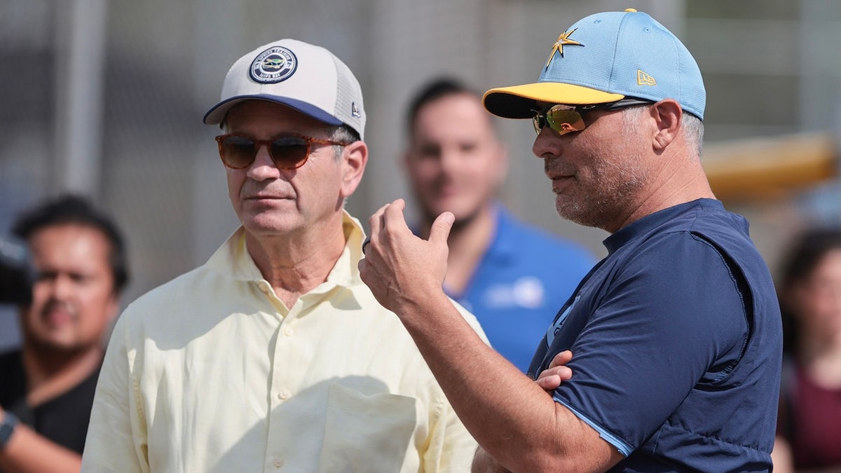 Tampa Bay Rays principal owner Stuart Sternberg and Manager Kevin Cash watch as pitchers and catchers hold their first Spring Training workout in Port Charlotte, Florida, on February 12, 2025, at Charlotte Sports Park. Hurricane Milton rips the roof off Tropicana Field in St. Petersburg, Florida, where the Rays usually play their regular season games. They play their regular season home games this year at the New York Yankees Spring Training stadium, Steinbrenner Field, which seats 11,000 people. 