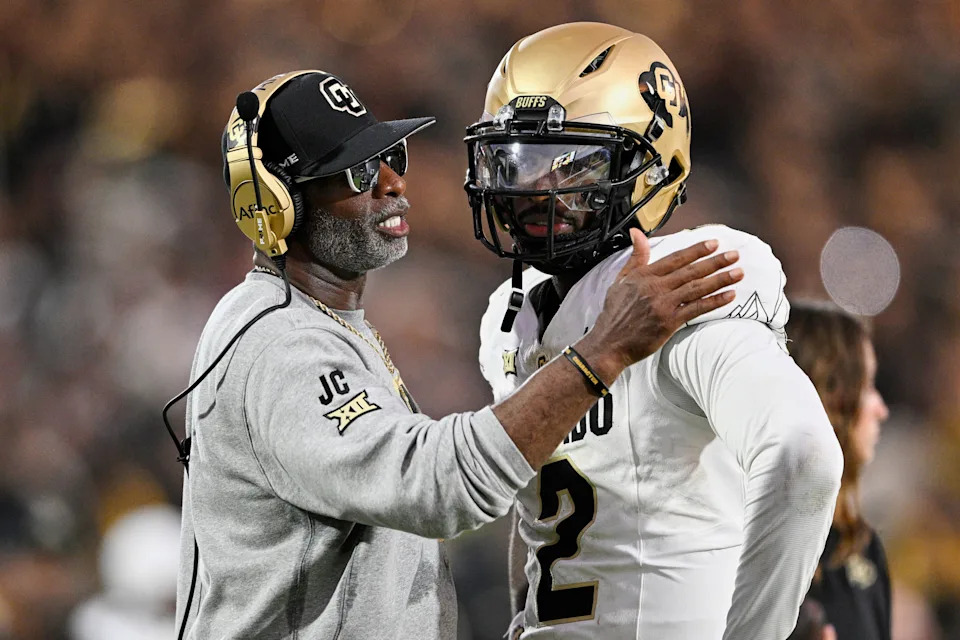 FILE - Colorado head coach Deion Sanders, left, talks with quarterback Shedeur Sanders (2) during a timeout in the second half of an NCAA college football game against Central Florida, Saturday, Sept. 28, 2024, in Orlando, Fla. (AP Photo/Phelan M. Ebenhack, File)