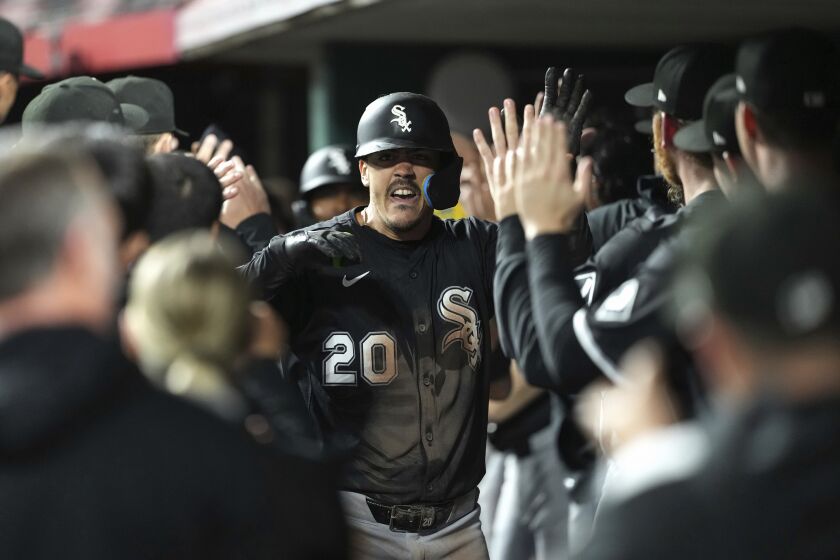 Miguel Vargas, center, is congratulated in the dugout after hitting a three-run home run in the 10th inning.