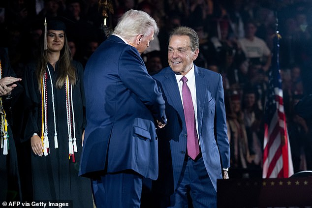 US President Donald Trump shakes hands with former Alabama football coach Nick Saban as he arrives to deliver commencement remarks at the University of Alabama in Tuscaloosa