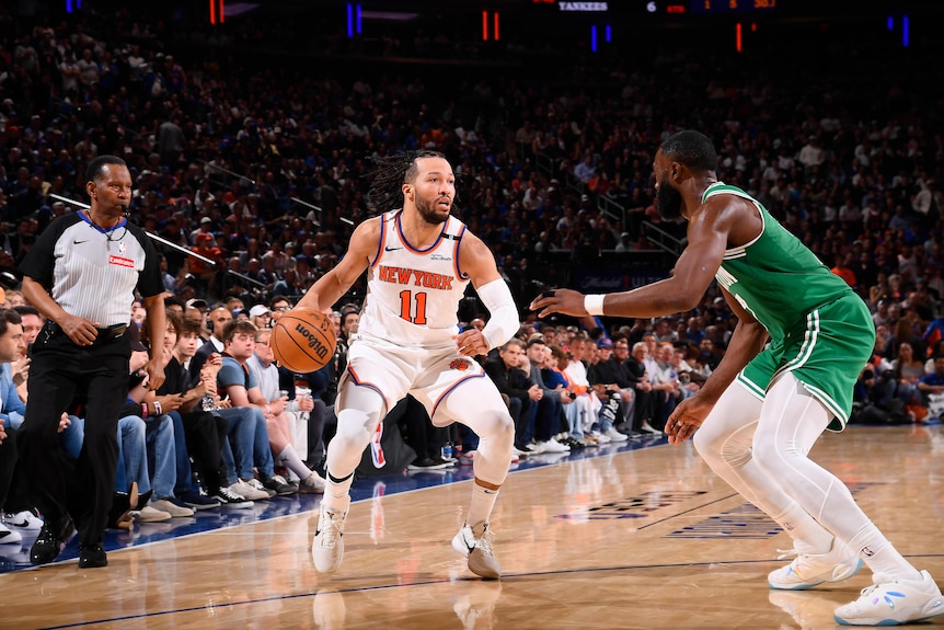 Jalen Brunson dribbles the ball in his right hand while defended