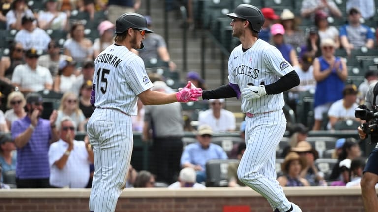 Colorado Rockies' Hunter Goodman (15) and Ryan McMahon (24) celebrate...