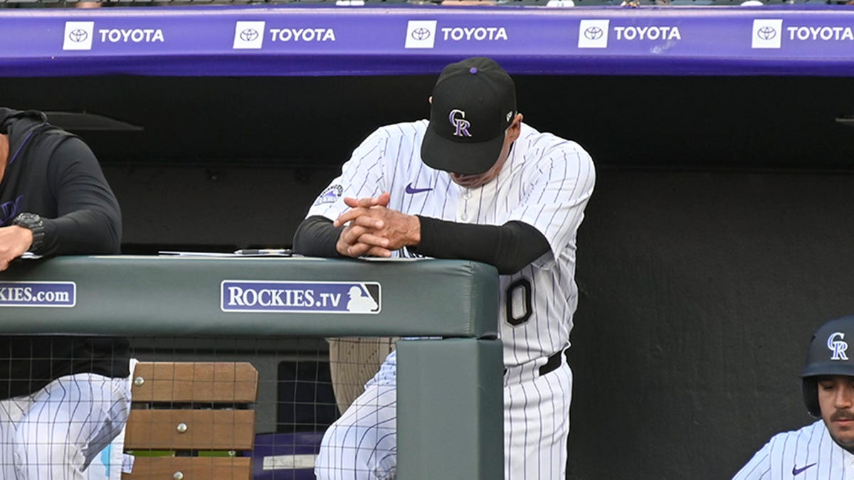 Rockies manager with head down in dugout