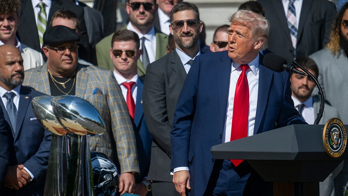Trump speaks at the podium in front of the Philadelphia Eagles